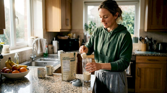 Woman making protein shake in her kitchen