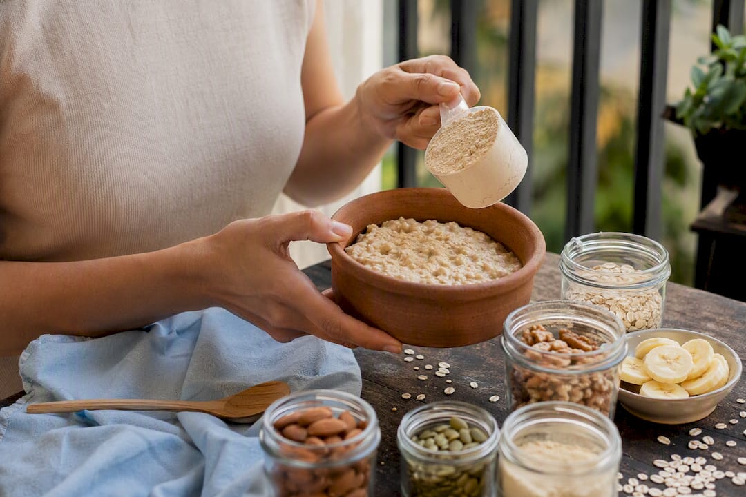 Hands preparing high-protein oatmeal bowl