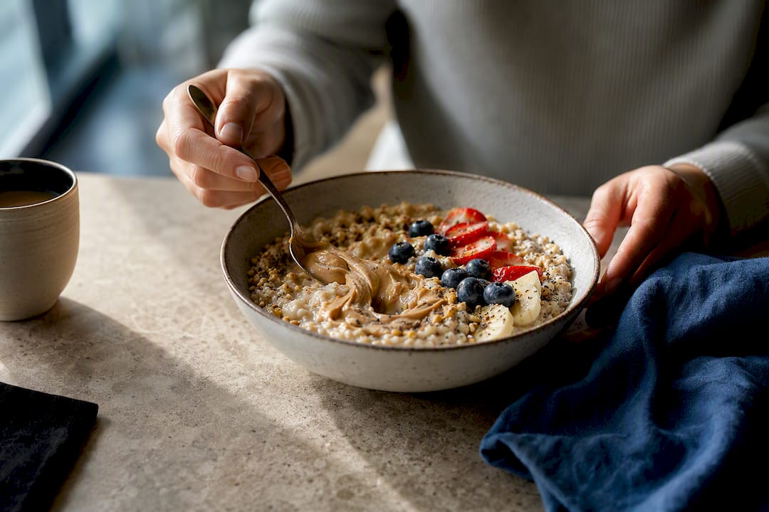 Layered high-protein oat bowl with berries and seeds
